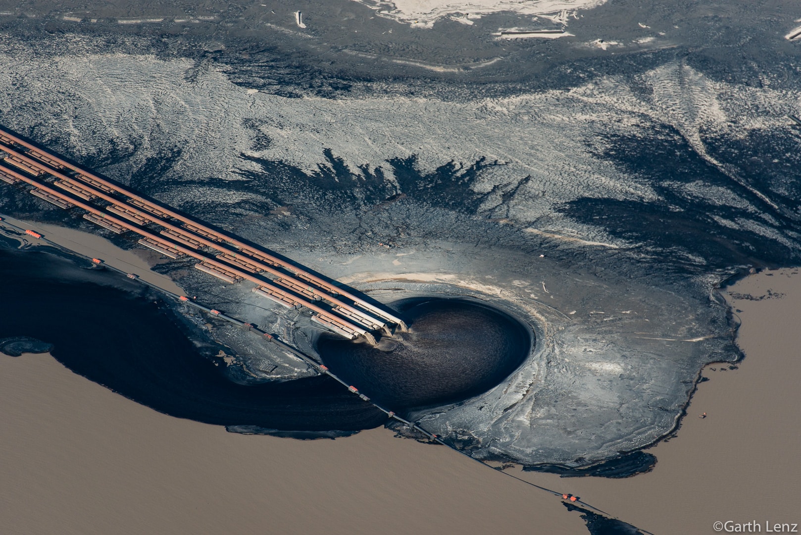 Pipe emptying effluent into Tailings pond in Northern Alberta